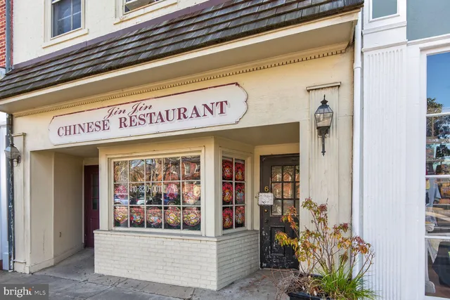 a view of a brick building with many windows and a tree