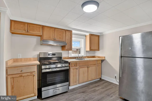 a kitchen with a stove a sink and a refrigerator
