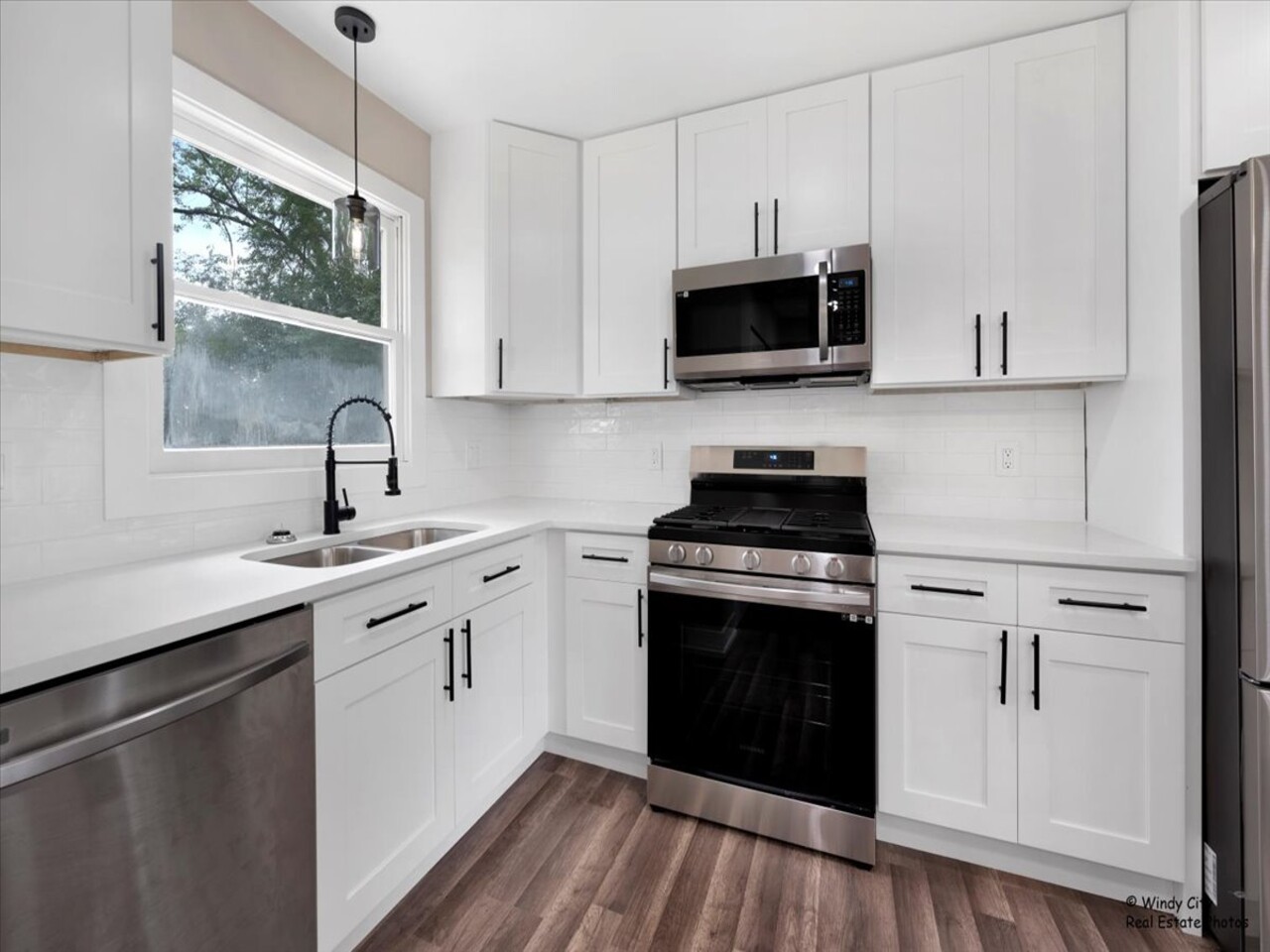 203 Elm Lane Streamwood, IL 60107 - Photo 4 of 23 a kitchen with stainless steel appliances white cabinets and a sink