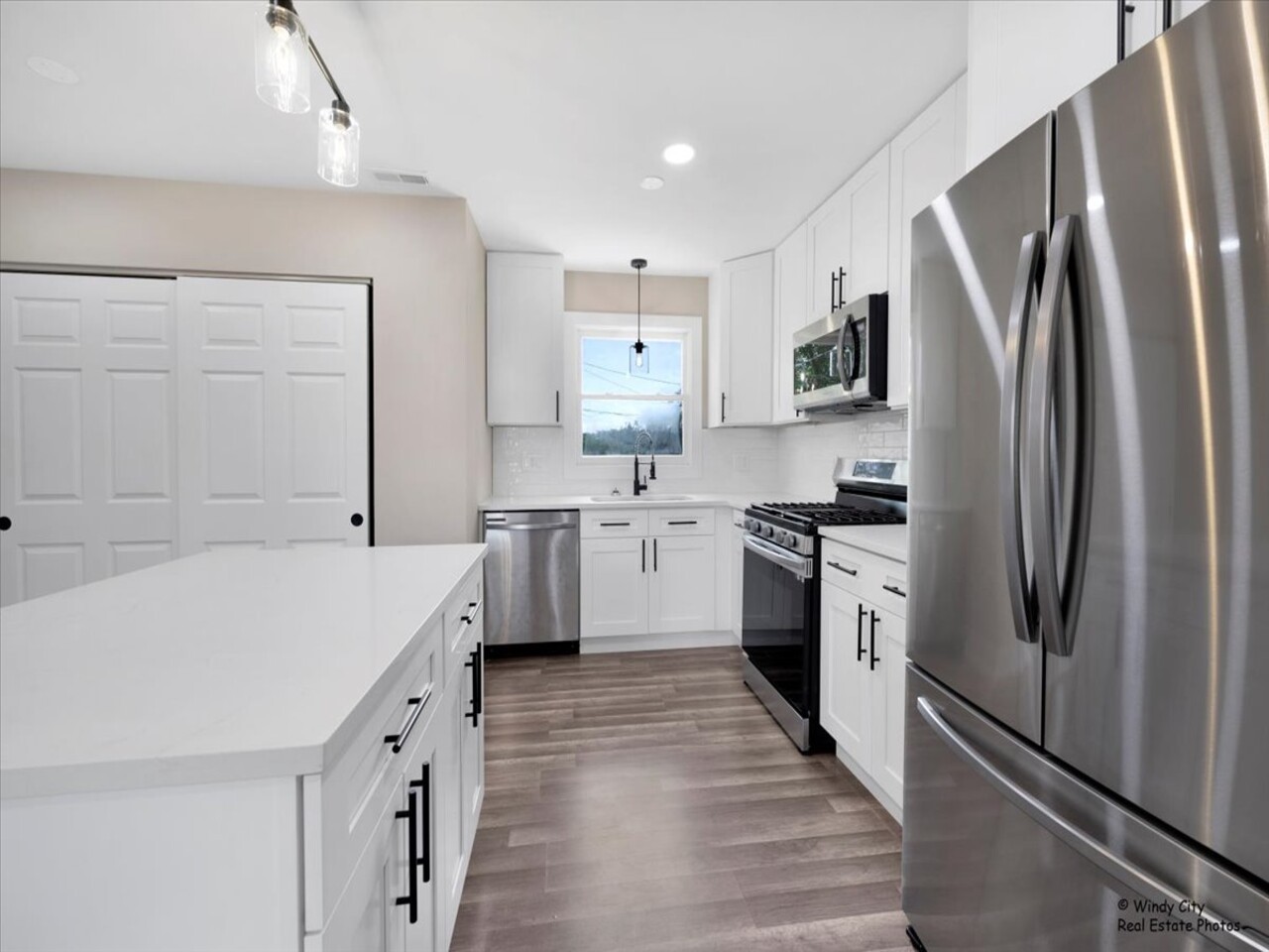 203 Elm Lane Streamwood, IL 60107 - Photo 5 of 23 a kitchen with white cabinets and stainless steel appliances