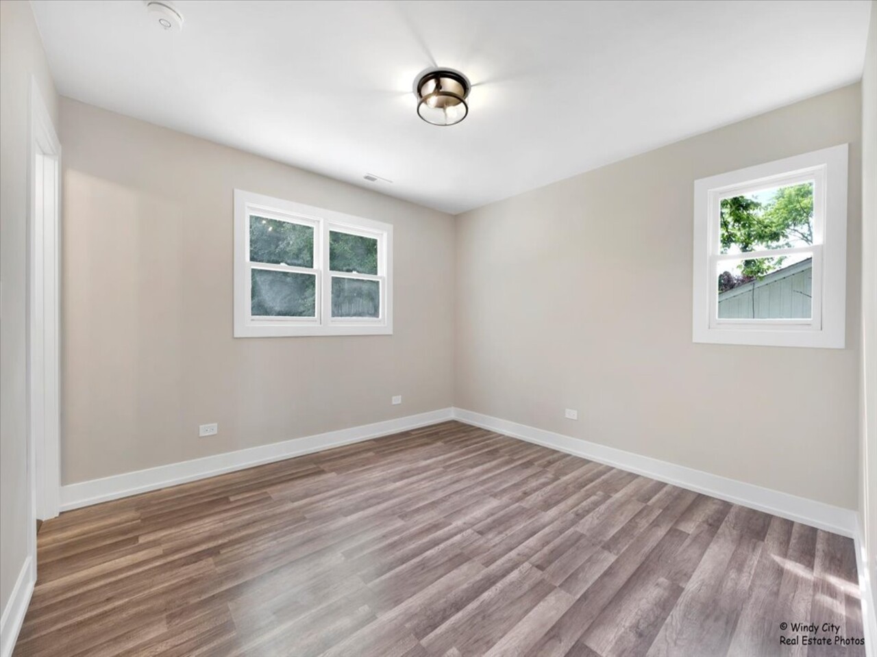203 Elm Lane Streamwood, IL 60107 - Photo 10 of 23 a view of an empty room with wooden floor and a window