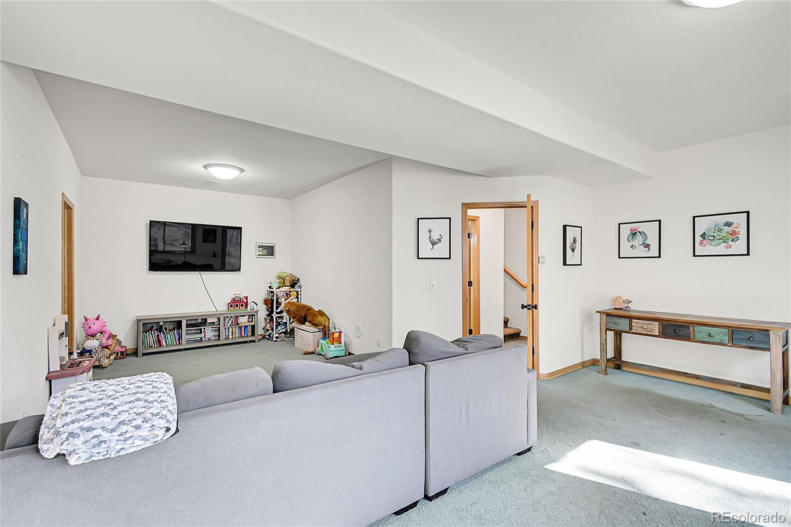 13382 Riley Peak Road Conifer, CO 80433 - Photo 20 of 25 a living room with furniture and a flat screen tv