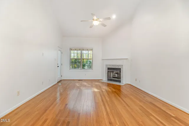 an empty room with windows and fireplace