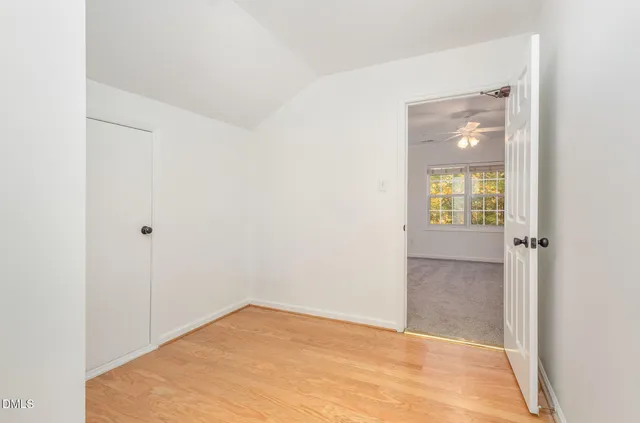 a view of an empty room with closet and a window