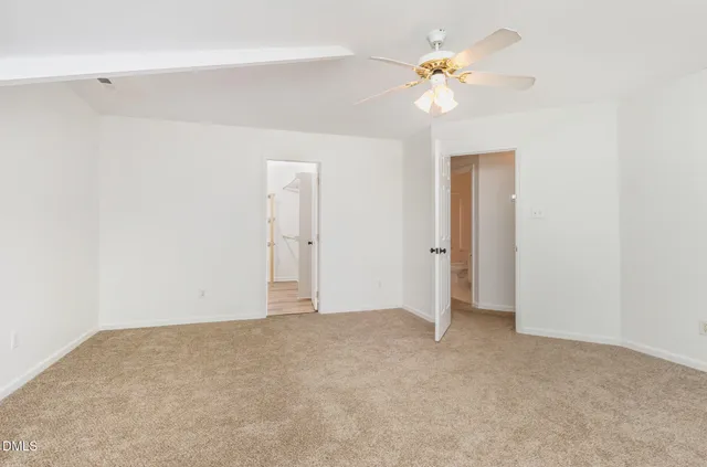 a view of an empty room with a ceiling fan