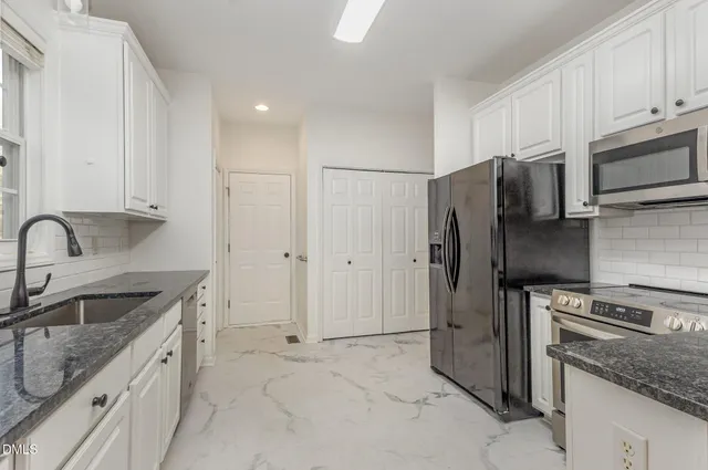 a kitchen with stainless steel appliances granite countertop a refrigerator sink and stove