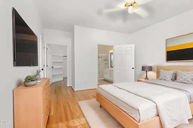 a spacious bedroom with a bed and a flat screen tv