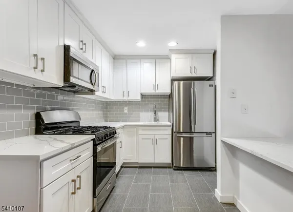 a kitchen with cabinets stainless steel appliances and a counter space