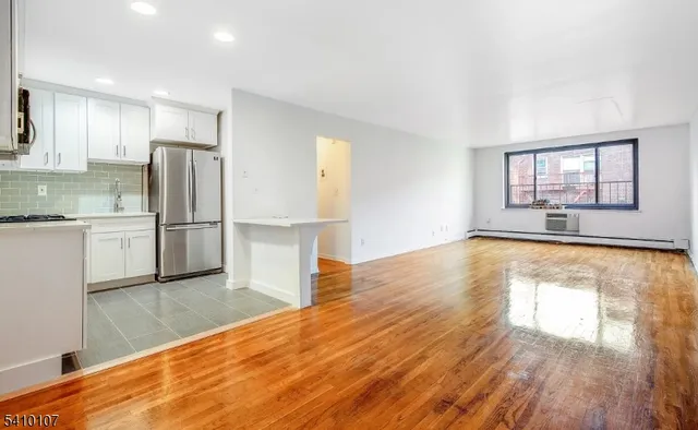 a view of a kitchen with wooden floor and a refrigerator