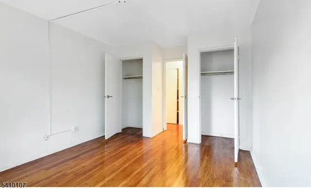 an empty room with wooden floor and closet