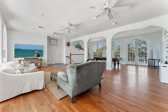 a kitchen with stainless steel appliances kitchen island granite countertop a wooden floor and white cabinets