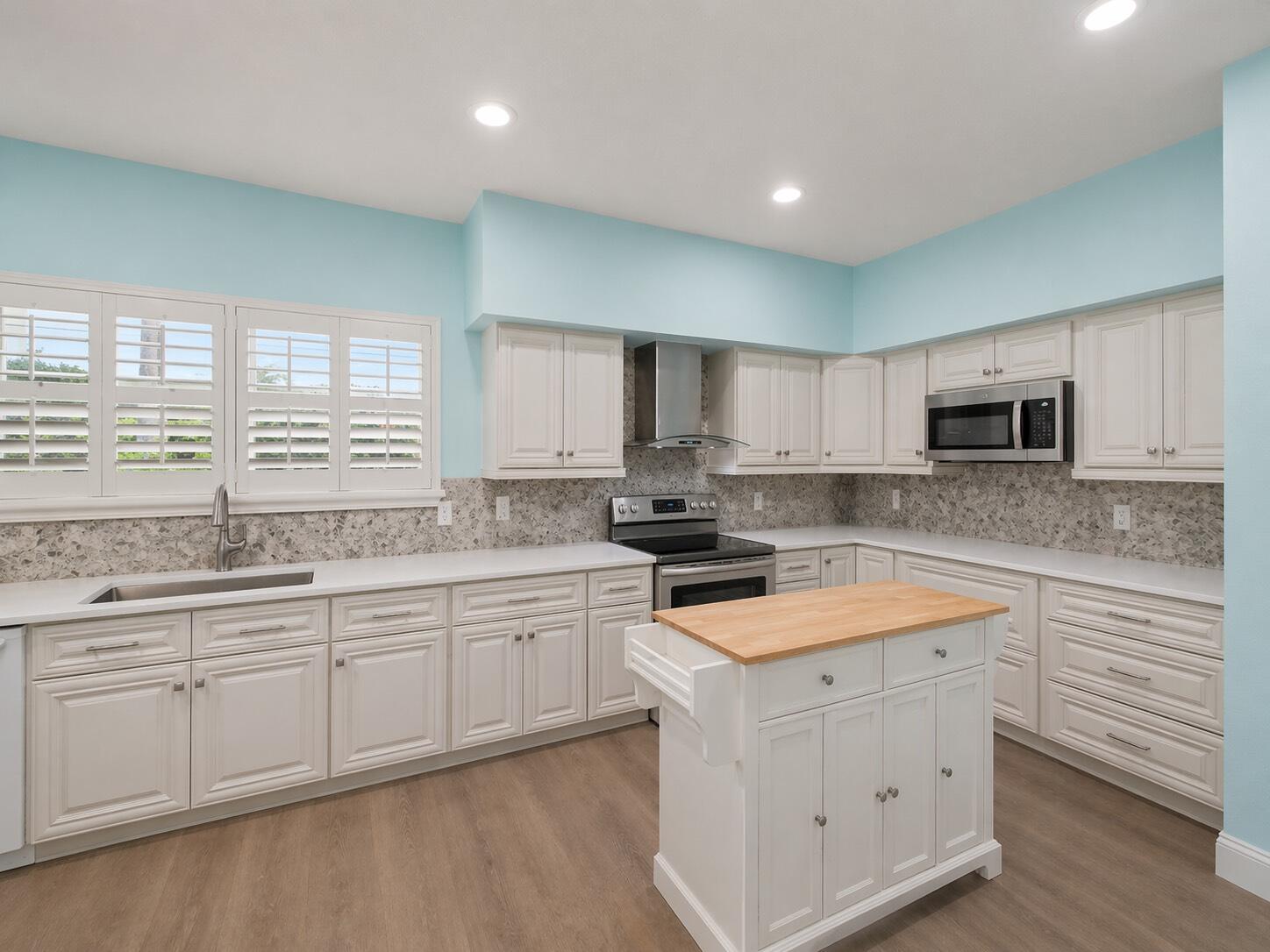 3012 Mainsail Circle Jupiter, FL 33477 - Photo 9 of 33 a kitchen with granite countertop white cabinets white appliances a sink and a window