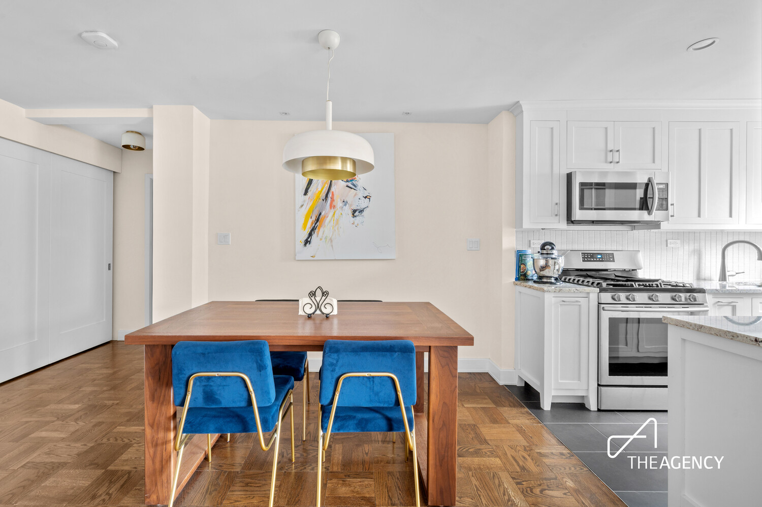 241 East 76th Street, Unit 5D Manhattan, NY 10021 - Photo 4 of 9 a kitchen with stainless steel appliances a dining table and chairs