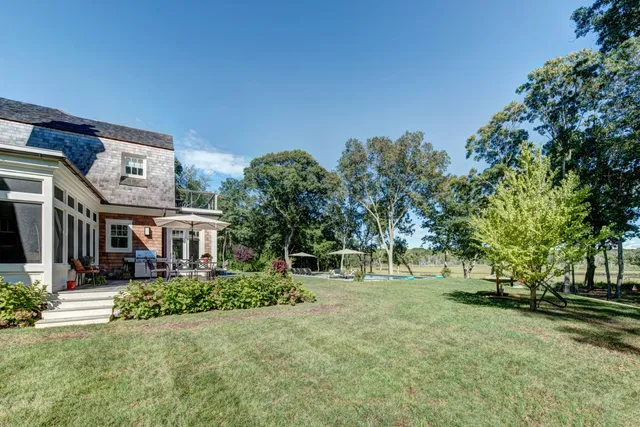 a view of a house with a yard and tree s