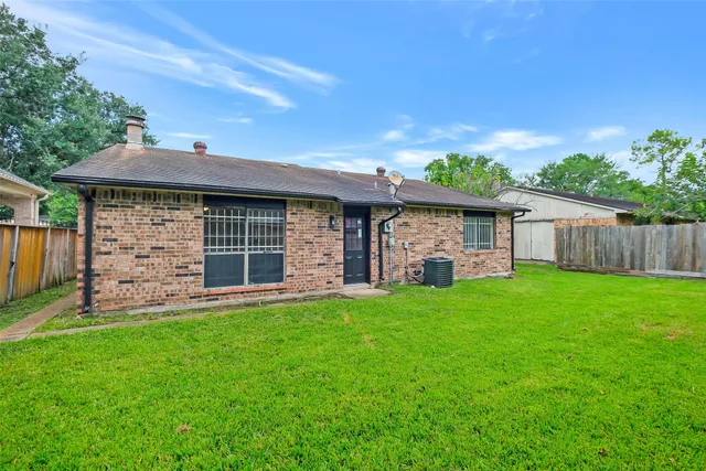 a view of a backyard with table and chairs and a large tree