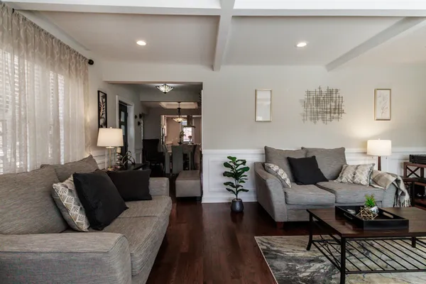 a kitchen with stainless steel appliances a dining table chairs stove refrigerator and cabinets