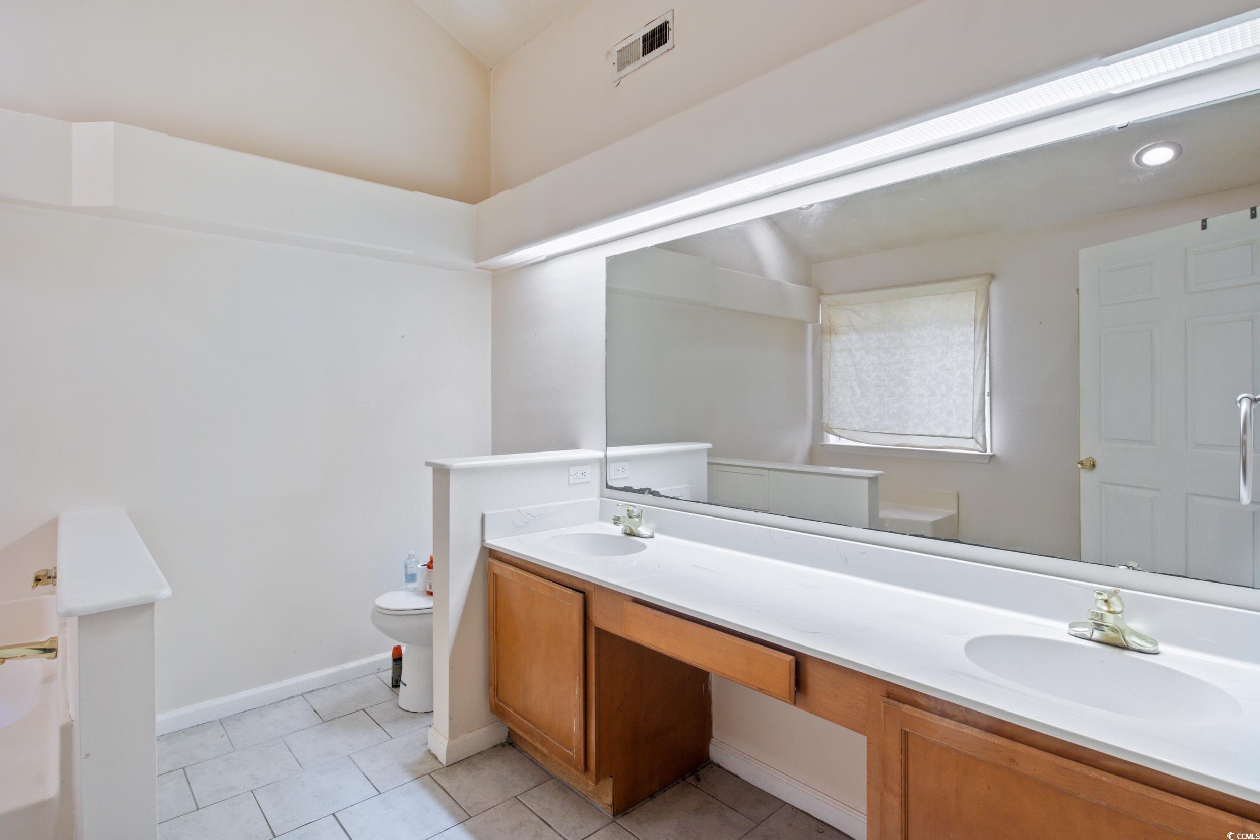 217 Nature Trail Little River, SC 29566 - Photo 23 of 37 Bathroom with vanity, toilet, and tile patterned f