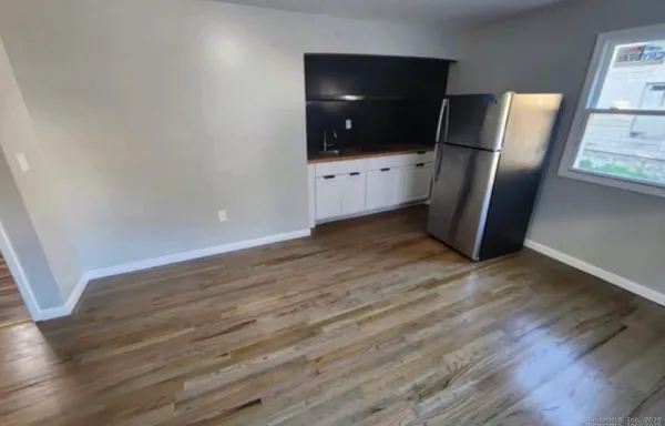 a view of a livingroom with wooden floor and white cabinet