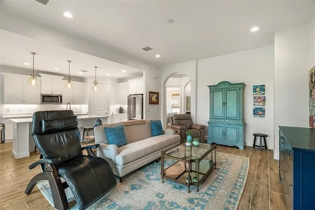 a living room with furniture and a view of kitchen