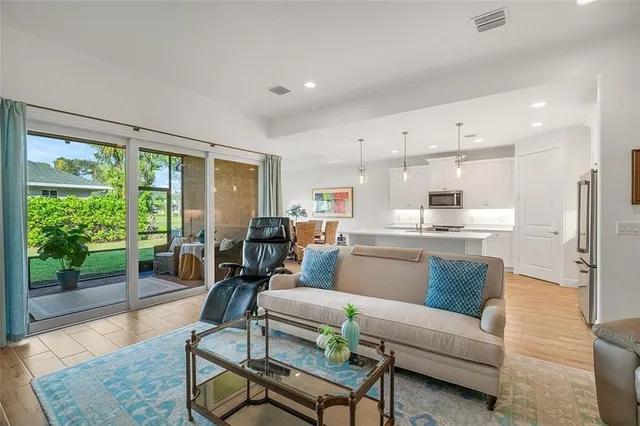 a living room with furniture wooden floor and a large window