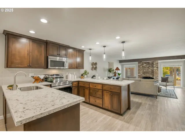 a kitchen with counter top space sink stove and wooden floor