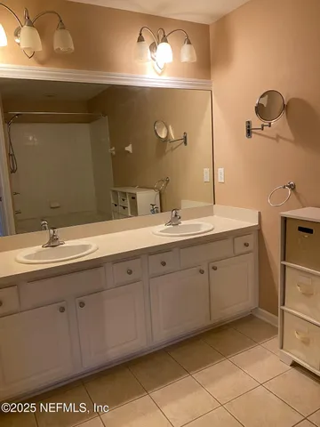 a spacious bathroom with a double vanity sink and a mirror