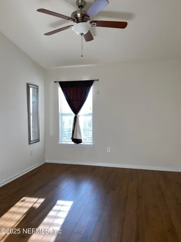 an empty room with a window and a fan