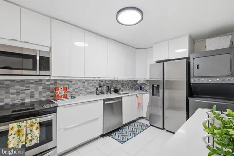 a kitchen with stainless steel appliances granite countertop a refrigerator sink and microwave