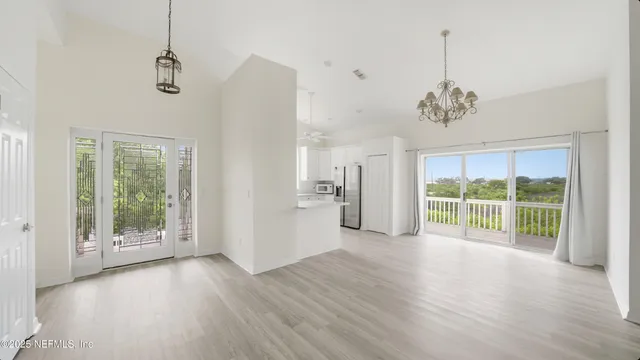 a view of an empty room with glass door and a window