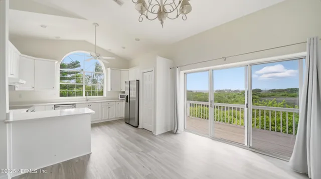 a view of a big room with wooden floor and windows