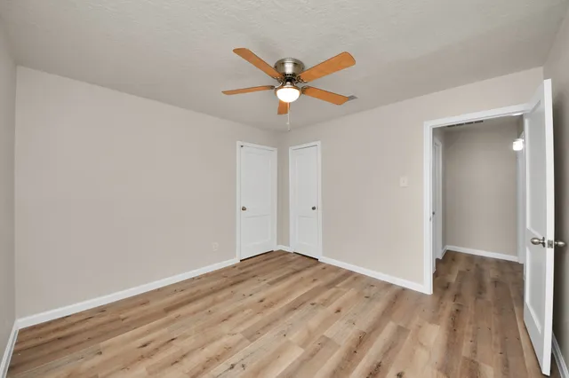 a view of empty room with wooden floor