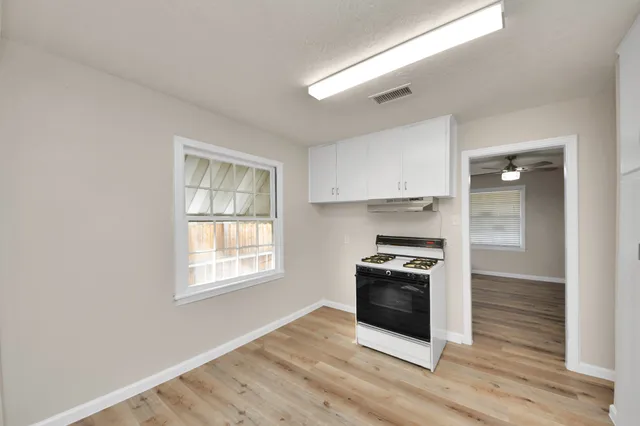 a kitchen with granite countertop a stove and a refrigerator