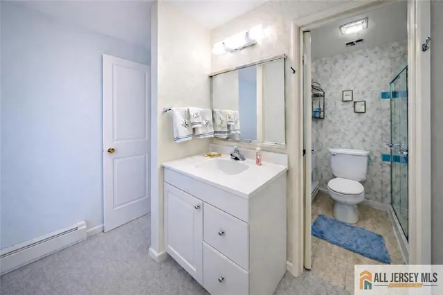a bathroom with a sink a toilet and shower