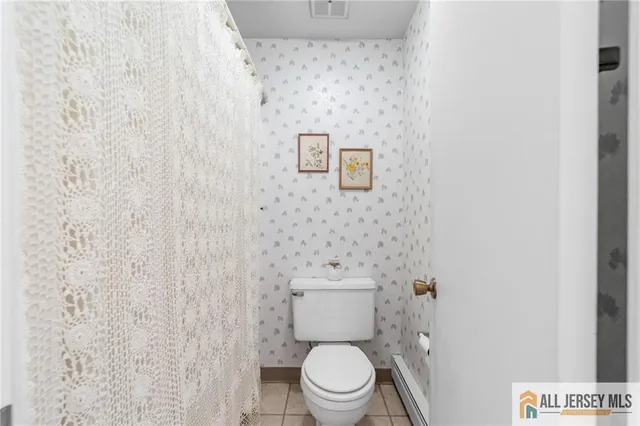 a white toilet sitting next to a white wall