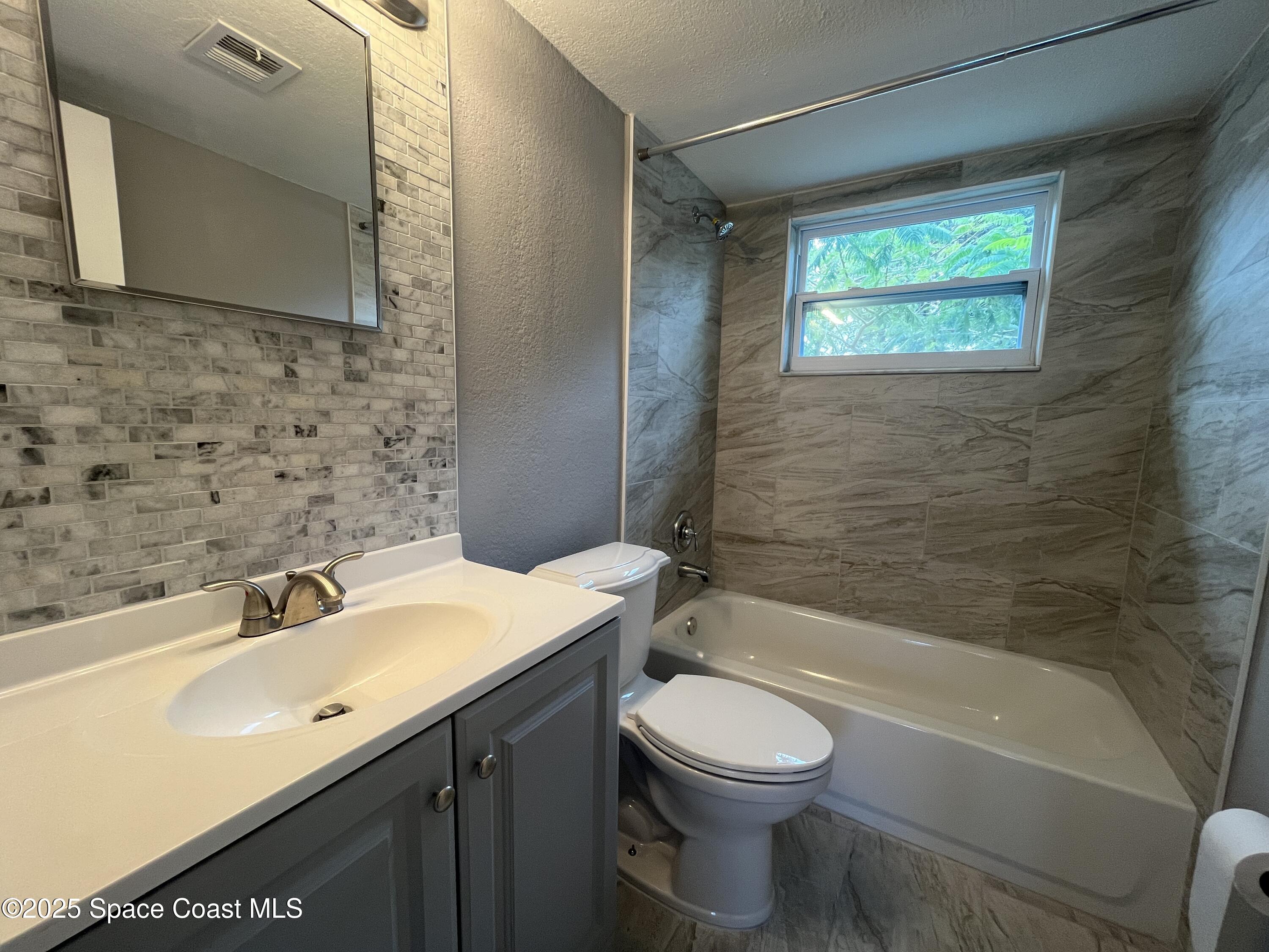 402 Adams Avenue, Unit E Cape Canaveral, FL 32920 - Photo 8 of 8 a bathroom with a sink a toilet and bathtub