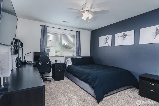 a bedroom with a bed couches chair and a large window