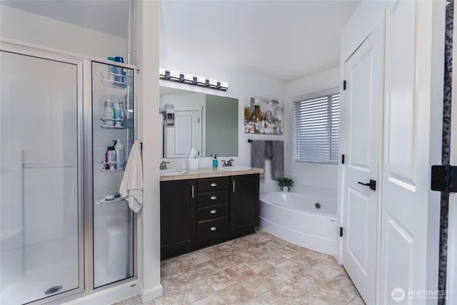 a bathroom with a double vanity sink mirror and shower