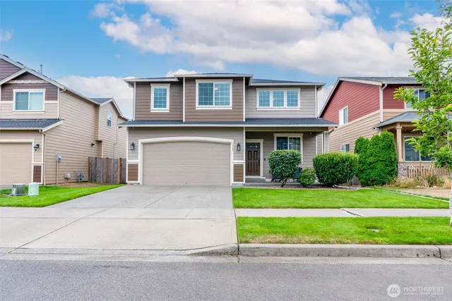 a front view of a house with a yard and garage