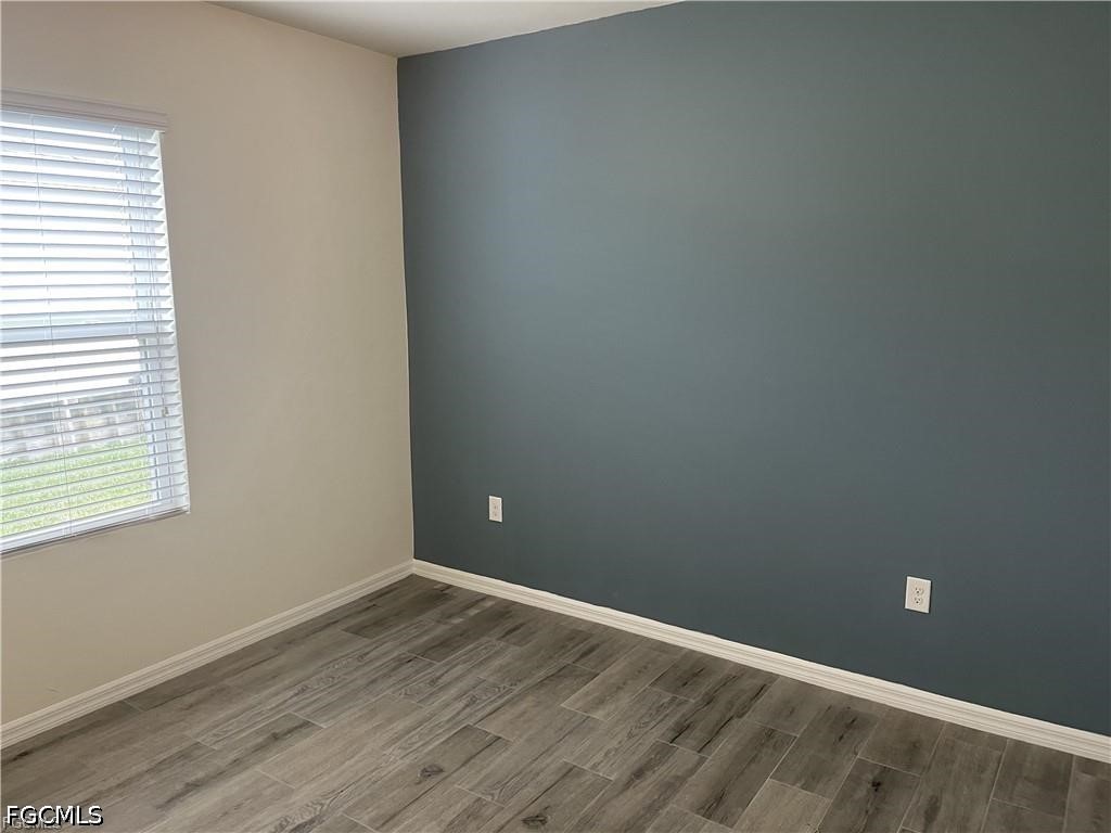 8187 Gopher Tortoise Trail Lehigh Acres, FL 33972 - Photo 13 of 23 an empty room with wooden floor and windows