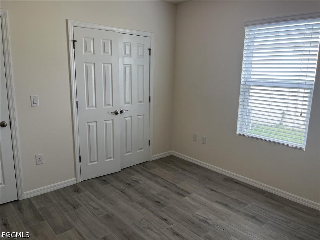 8187 Gopher Tortoise Trail Lehigh Acres, FL 33972 - Photo 14 of 23 an empty room with wooden floor closet and windows