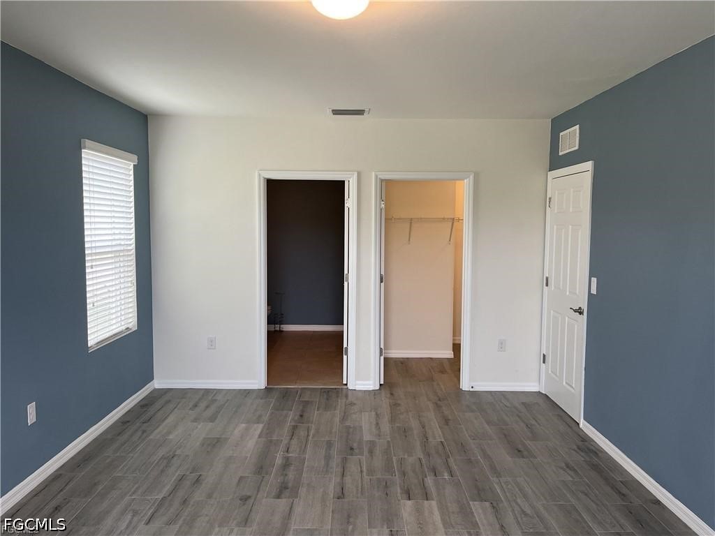 8187 Gopher Tortoise Trail Lehigh Acres, FL 33972 - Photo 17 of 23 an empty room with wooden floor and windows