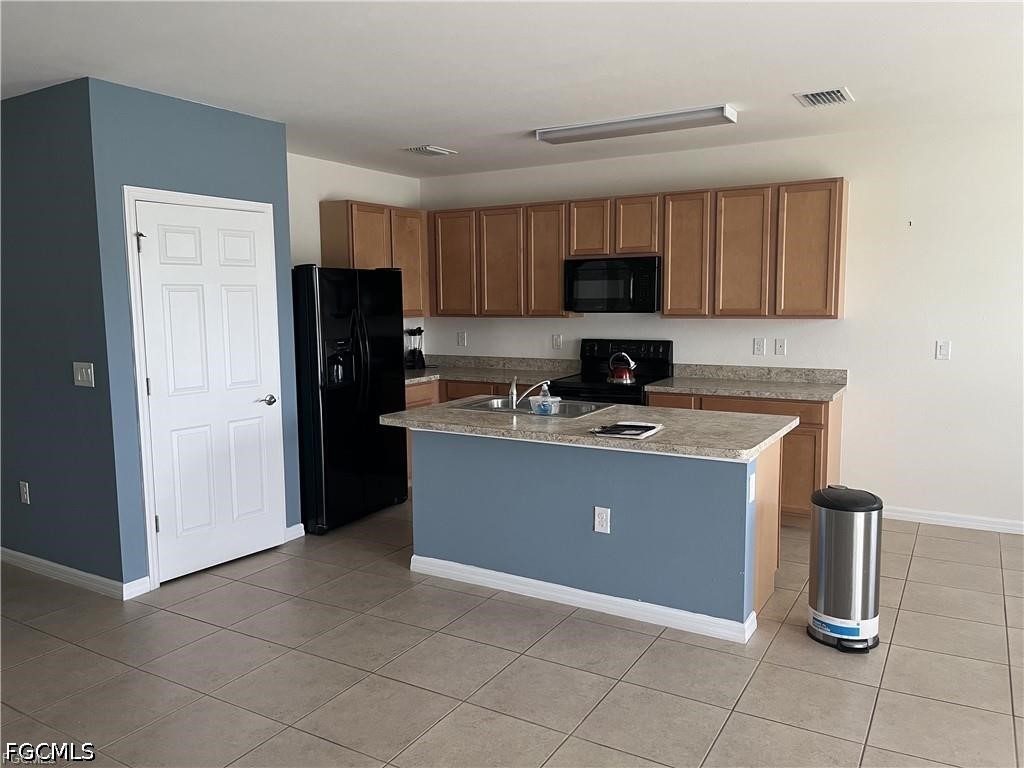 8187 Gopher Tortoise Trail Lehigh Acres, FL 33972 - Photo 18 of 23 a kitchen with stainless steel appliances granite countertop a stove a refrigerator a sink a microwave and a refrigerator