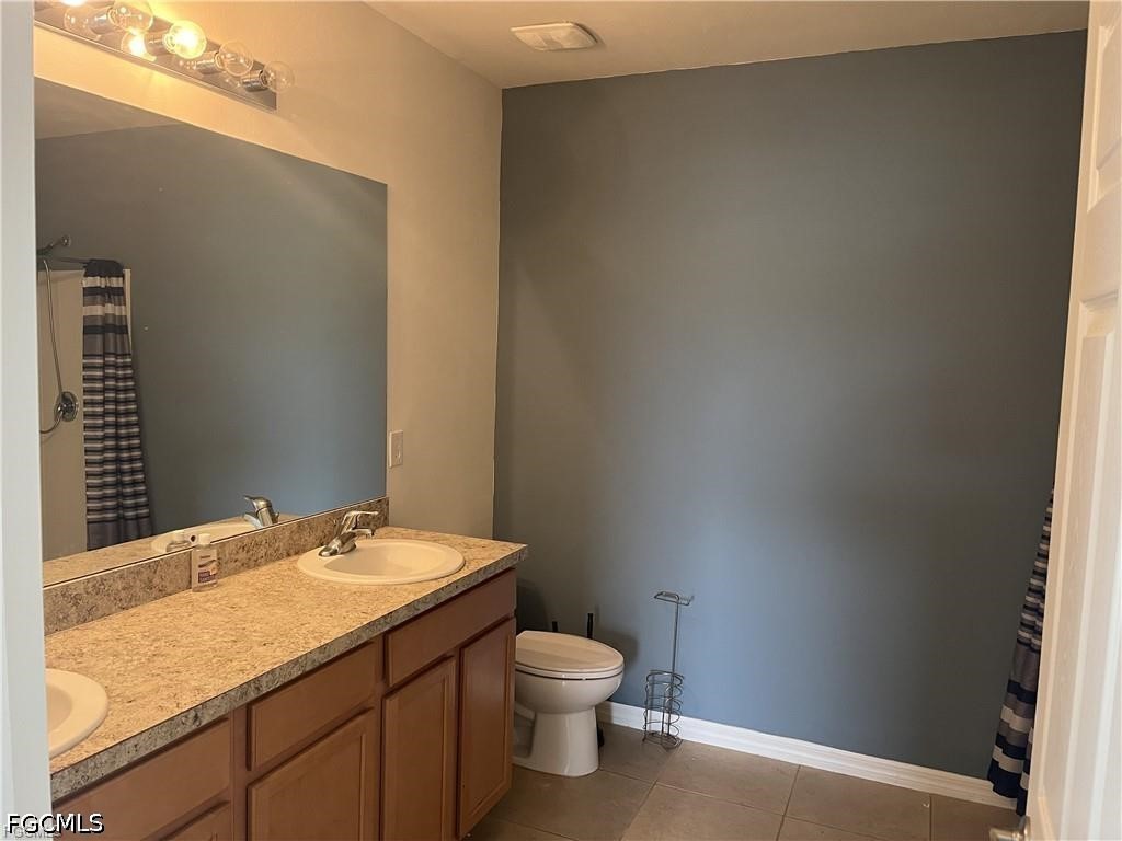 8187 Gopher Tortoise Trail Lehigh Acres, FL 33972 - Photo 20 of 23 a bathroom with a granite countertop toilet and a sink