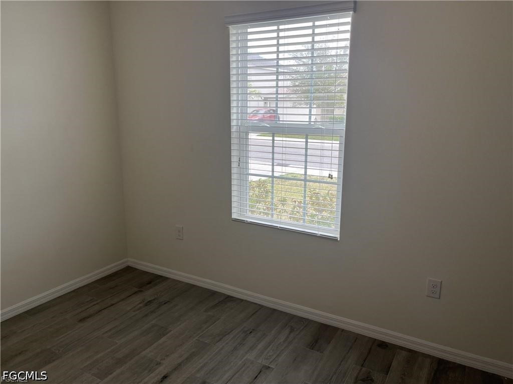 8187 Gopher Tortoise Trail Lehigh Acres, FL 33972 - Photo 21 of 23 an empty room with wooden floor and windows