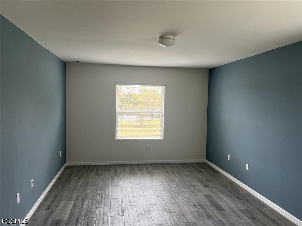 8187 Gopher Tortoise Trail Lehigh Acres, FL 33972 - Photo 23 of 23 an empty room with wooden floor and windows
