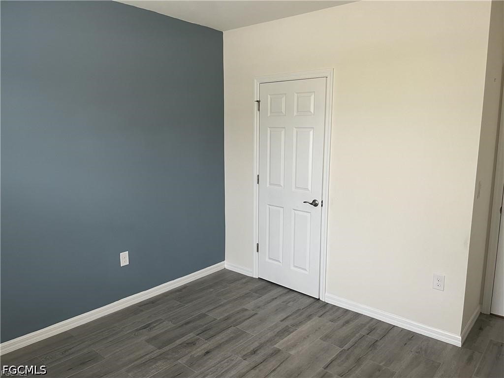 8187 Gopher Tortoise Trail Lehigh Acres, FL 33972 - Photo 8 of 23 a view of an empty room with wooden floor