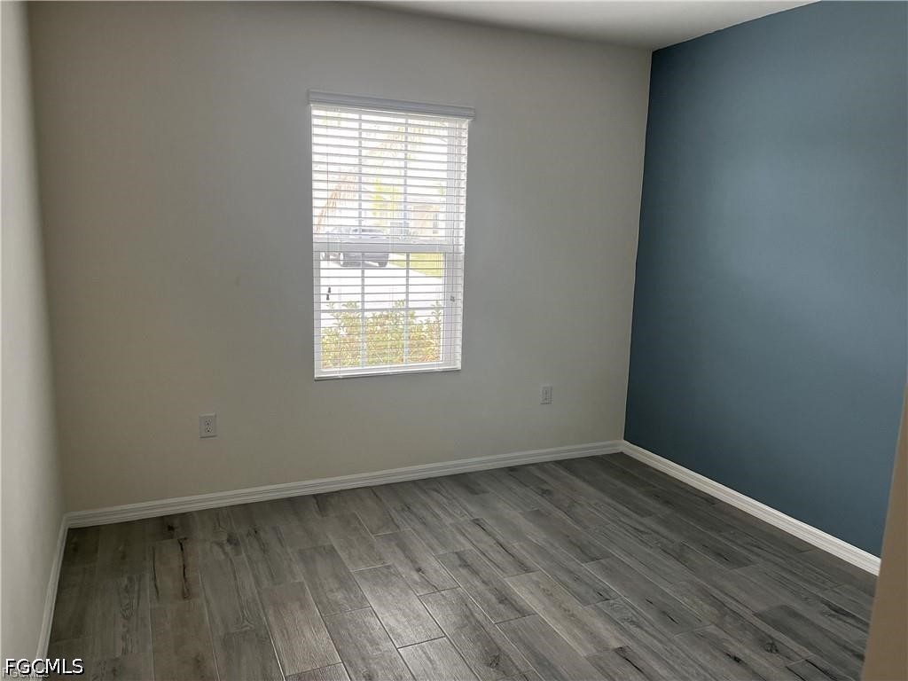 8187 Gopher Tortoise Trail Lehigh Acres, FL 33972 - Photo 9 of 23 an empty room with wooden floor and windows