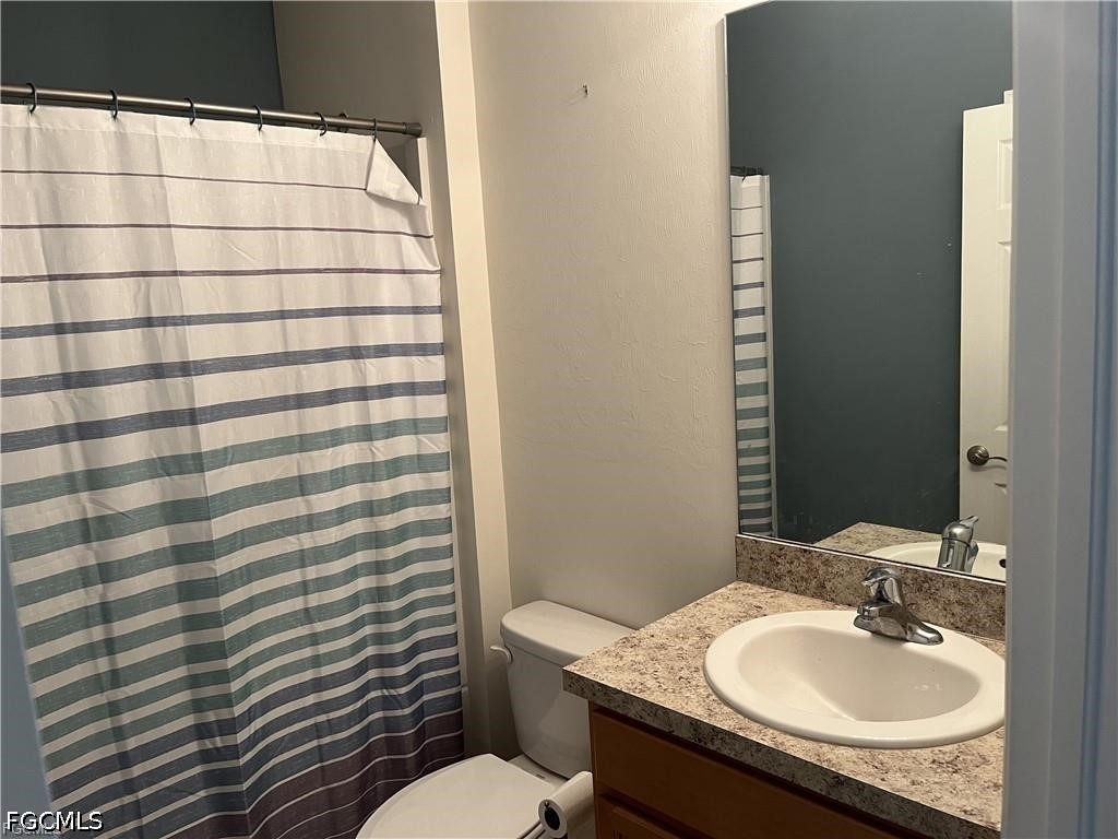8187 Gopher Tortoise Trail Lehigh Acres, FL 33972 - Photo 10 of 23 a bathroom with a granite countertop sink toilet and mirror
