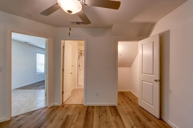 a view of a room with wooden floor and a kitchen
