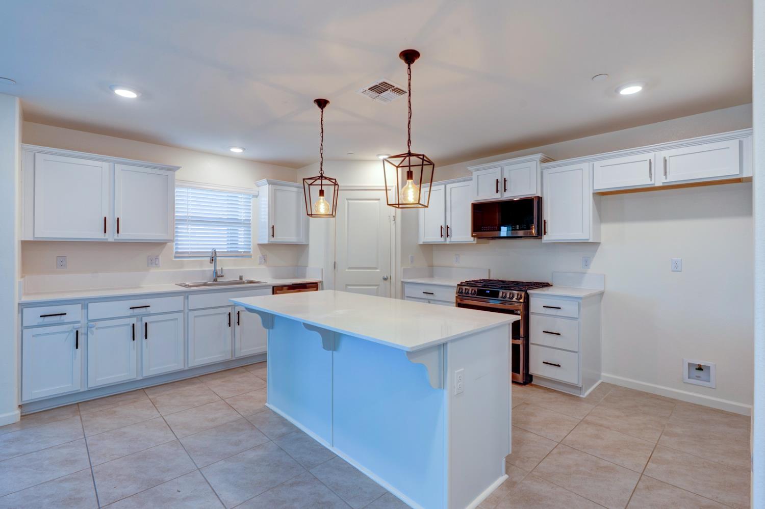753 Heitz Way Merced, CA 95348 - Photo 22 of 70 a kitchen with stainless steel appliances granite countertop a sink a stove and a refrigerator